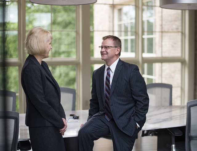 Lawyer sitting and talking with client who is standing